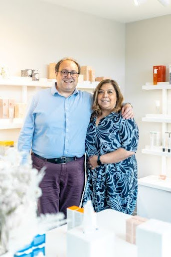Two people standing in a skincare business smiling at the camera.